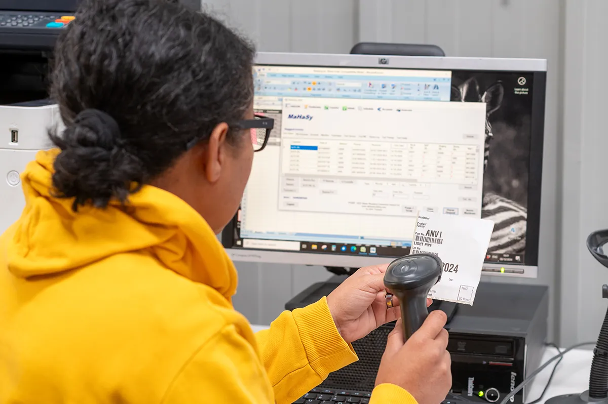 image of female scanning a bar code and working on computer